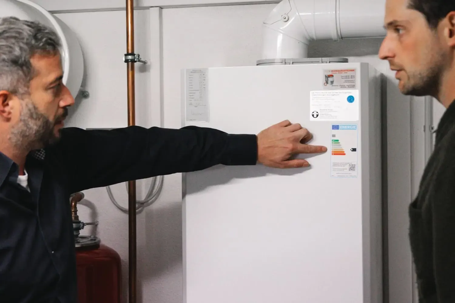 Michael Sever erklärt einem Kunden das Energielabel der Heizungsanlage